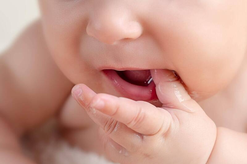 Khi răng chuẩn bị mọc ra, bé thường có biểu hiện hay đưa tay vào miệng để cắn rất nhiều